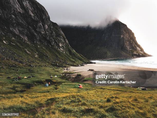 beach with a mountain backdrop, grass and tents - lofoten-en-vesterålen stockfoto's en -beelden