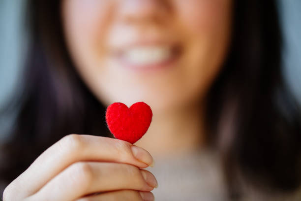 woman holding tiny heart - physical health benefits stock pictures, royalty-free photos & images