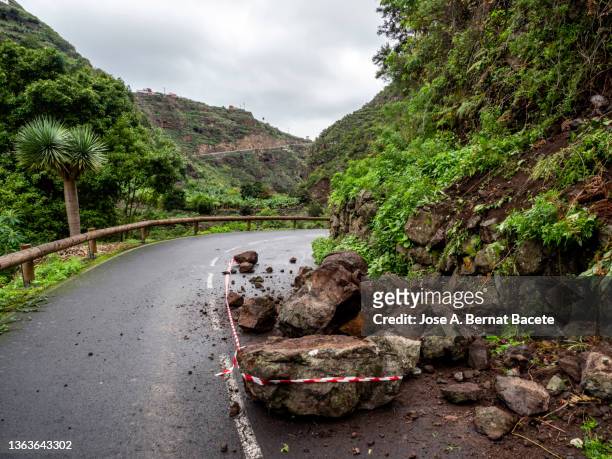 road cut by rockslides on the road. - erdrutsch stock-fotos und bilder