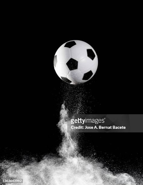 impact and rebound of a soccer ball on a surface of earth and gunpowder on a black background - ballon rebond stock pictures, royalty-free photos & images