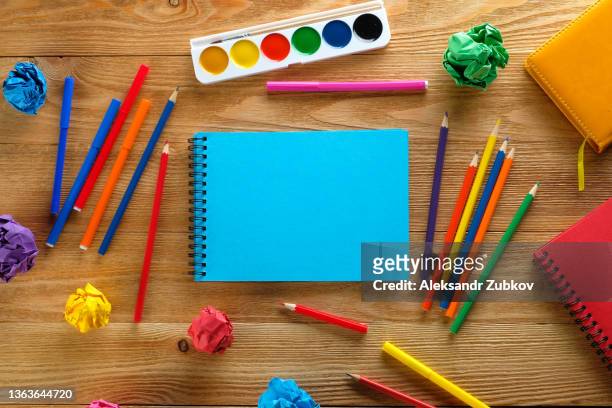 colored markers and pencils, a blank drawing pad, watercolor paints on a wooden table. topics of children's creativity, school and preschool education, hobbies. copy space. drawing lessons. - 美術工芸用品 ストックフォトと画像