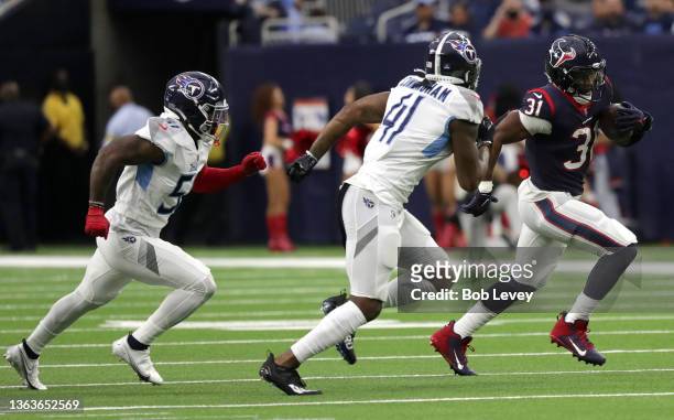 David Johnson of the Houston Texans runs the ball in front of Zach Cunningham and David Long of the Tennessee Titans during the first quarter at NRG...
