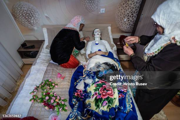Muslim women put traditional make-up on the face of the bride Nefie Eminkova on her wedding day on January 9, 2022 in Ribnovo, Bulgaria. Bulgarian...