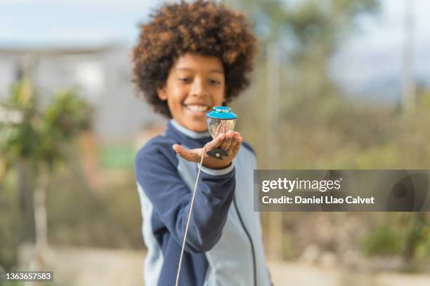 smiling little boy watching spinning top - peonza stockfoto's en -beelden