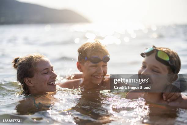 kids enjoying summer vacations in the sea - three girls at beach stock pictures, royalty-free photos & images