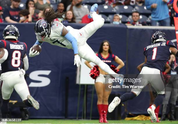 Onta Foreman of the Tennessee Titans leaps over Lonnie Johnson of the Houston Texans during the first half at NRG Stadium on January 09, 2022 in...