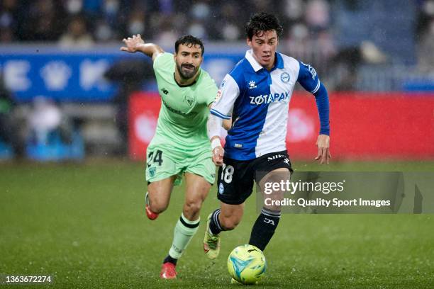 Facundo Pellistri of Deportivo Alaves compete for the ball with Mikel Balenciaga of Athletic Club during the La Liga Santander match between...