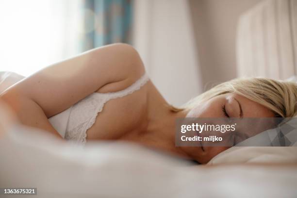 junge frau schlafen im schlafzimmer - lying on side stock-fotos und bilder