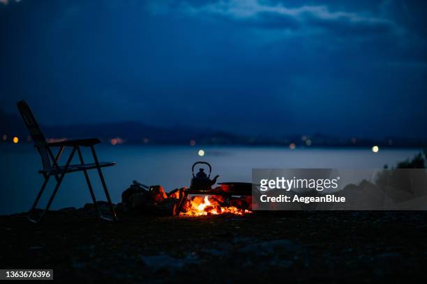 campfire and camping chair at dusk - campfire background stock pictures, royalty-free photos & images