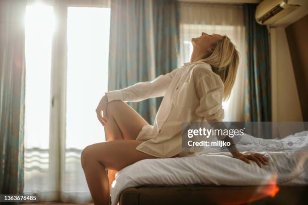 beautiful young woman relaxing in bedroom - bed sun stock pictures, royalty-free photos & images