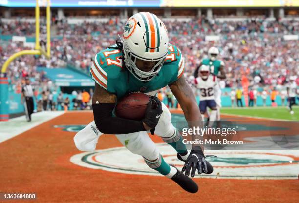 Jaylen Waddle of the Miami Dolphins completes a 7-yard reception for a touchdown over the New England Patriots in the first quarter of the game at...