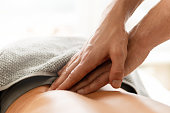 Closeup of masseur man's hands during back massage for young woman