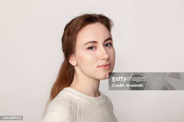 nahaufnahme studioporträt der attraktiven 19-jährigen frau mit braunem pferdeschwanzhaar in weißem pullover auf weißem hintergrund - gray eyes stock-fotos und bilder
