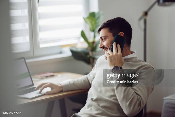 home office: an anonymous man using a laptop for online trading while working from home - looks right stockfoto's en -beelden