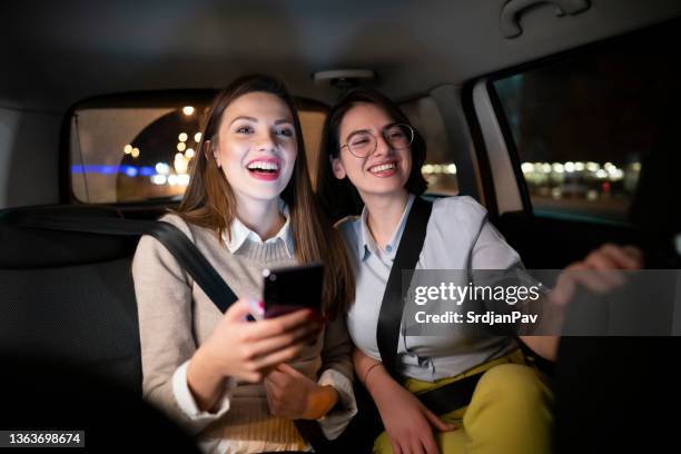 young women having fun while driving in the taxi - taxi driver 個照片及圖片檔