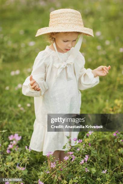 cute girl walking in the park in romantic dress and straw hat. - girl dress romantic stock-fotos und bilder