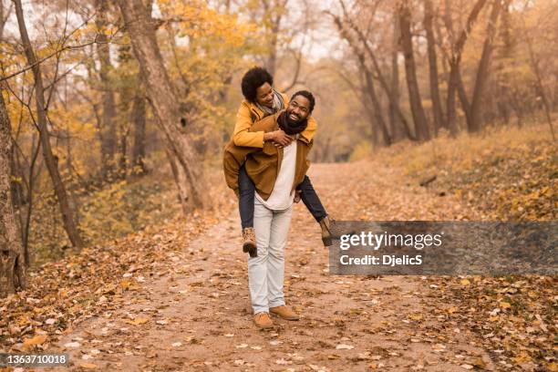 happy african american couple having fun in autumn park. - black couple date stockfoto's en -beelden