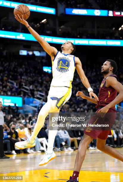 Jordan Poole of the Golden State Warriors shoots over Evan Mobley of the Cleveland Cavaliers during the third quarter at Chase Center on January 09,...