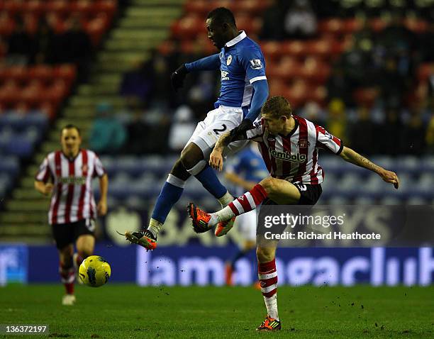 James McClean of Sunderland is tackled by Steve Gohouri of Wigan during the Barclays Premier League match between Wigan Athletic and Sunderland at...