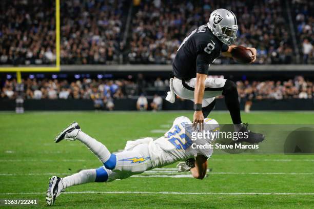 Alohi Gilman of the Los Angeles Chargers tackles Marcus Mariota of the Las Vegas Raiders during the fourth quarter at Allegiant Stadium on January...