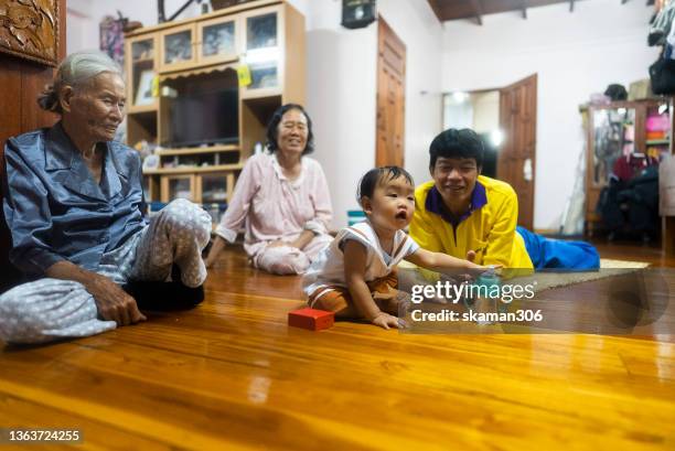 asian family with one child 3rd generation positive emotion great-grandmother  playing with grand daughter at home domestic life - great granddaughter stock pictures, royalty-free photos & images