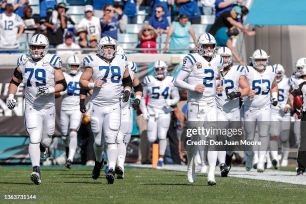 Tackle Eric Fisher, center Ryan Kelly and quarterback Carson Wentz of the Indianapolis Colts lead teammates onto the field before the game against...