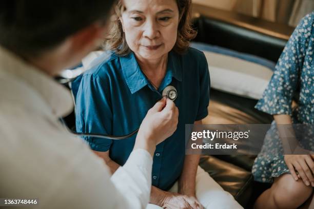 close-up, asian doctor concentrate on listening heartbeat of senior woman. - lunga bildbanksfoton och bilder