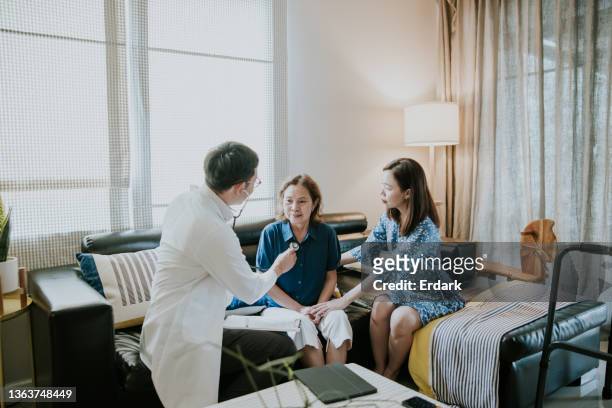 doctor on call visiting for senior woman at home. - woman home with sick children stock pictures, royalty-free photos & images