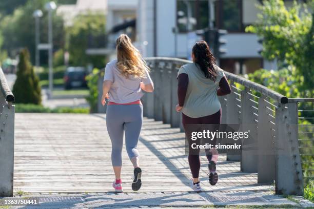 women running in public park - pedal pushers 個照片及圖片檔