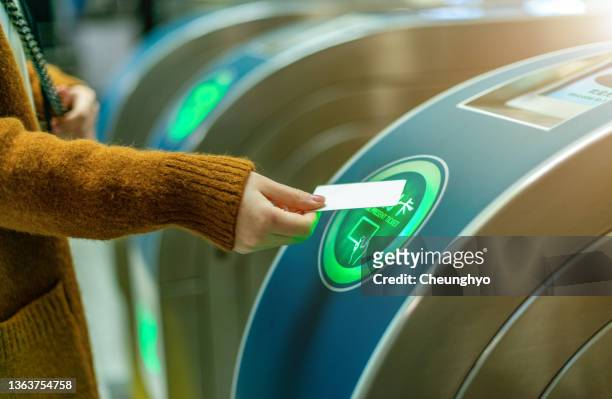 a woman prepares to swipe a ticket to pass a subway gate - 改札 ストックフォトと画像