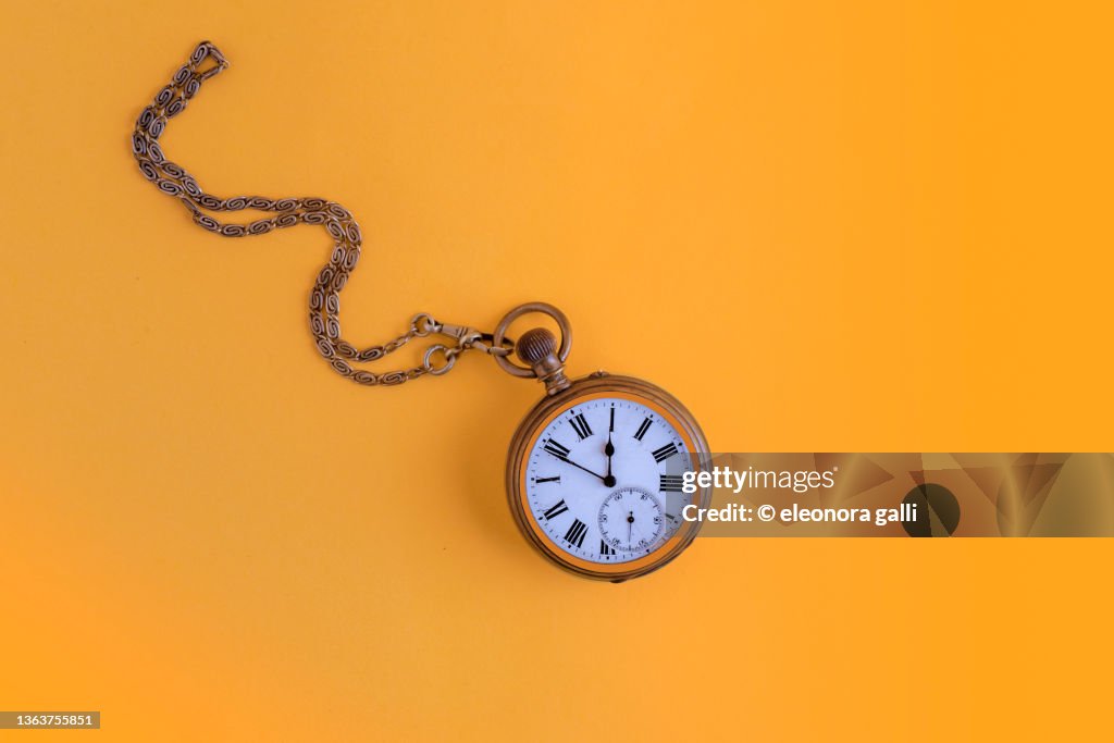 Pocket watch on a yellow background