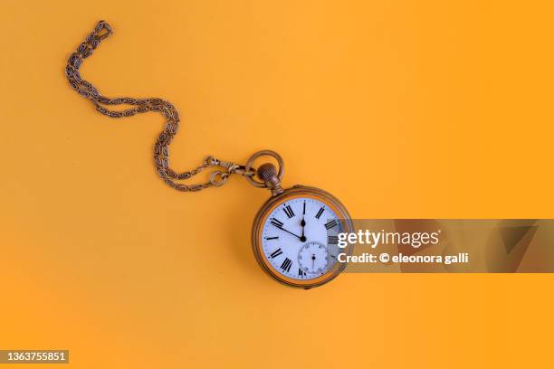 pocket watch on a yellow background - antique watch stock pictures, royalty-free photos & images