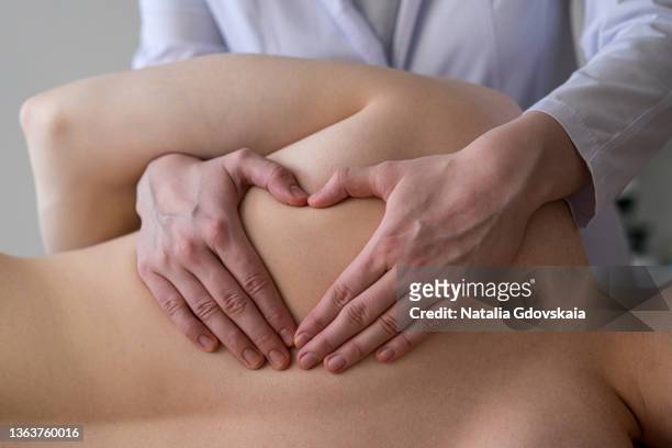 closeup of osteopathic masseur massages patient back, relieving tension from muscles and toning up - kinésithérapeute photos et images de collection