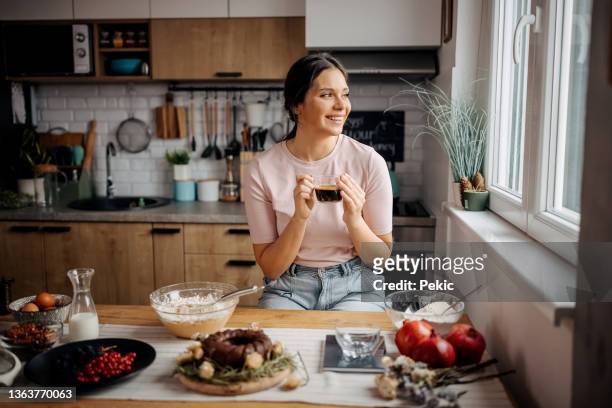 young beautiful woman drinking coffee in kitchen - coffee cake stockfoto's en -beelden