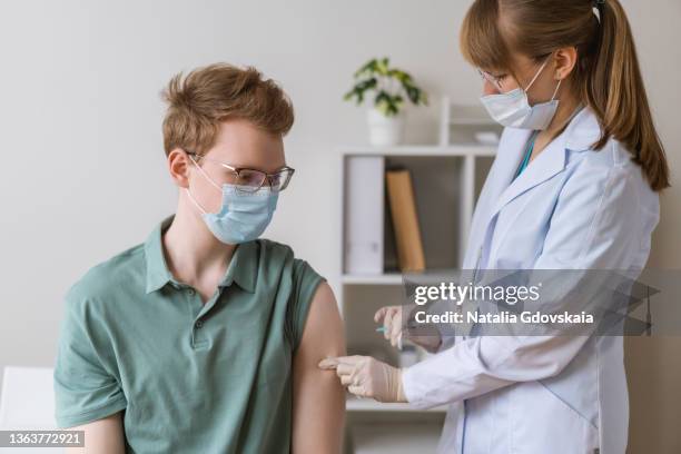 healthcare worker giving effective injection to patient in clinic. preventing infectious diseases - pocken stock-fotos und bilder