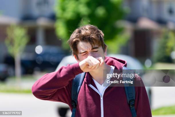 a young person with cold symptoms outside - blowing nose stock pictures, royalty-free photos & images