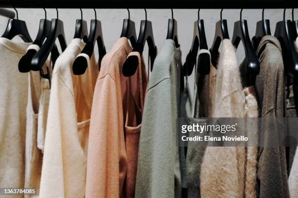 clothes are neatly hung by color, systematization of clothes in closet. shopping fashion sale background. colorful clothes on hangers. selective focus - wardrobe 個照片及圖片檔