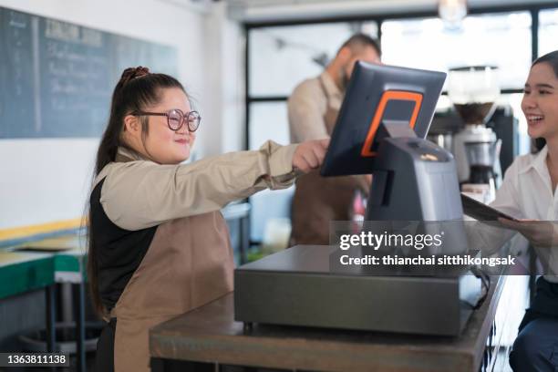 cashier counter pay bill,young woman with down syndrome working at cafe. - paying employees stock pictures, royalty-free photos & images