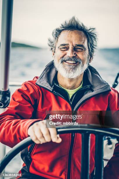 skipper sailing on sailboat - man stoer stockfoto's en -beelden