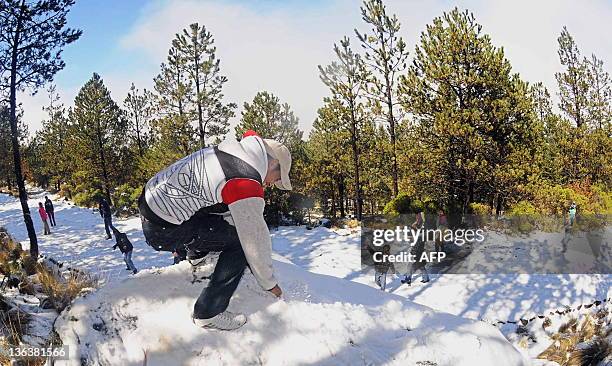 Residents play with snow at the slope of a mountain in Cofre de Perote, Veracruz state, Mexico, on January 3, 2012. Unusual snow fell in Veracruz...