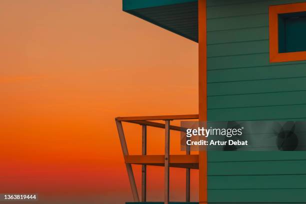 dramatic sunset sky with the colorful lifeguard hut in miami beach. - beach house balcony fotografías e imágenes de stock