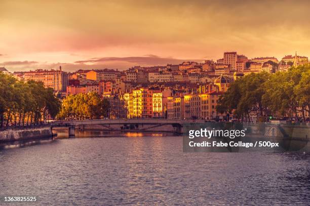 scenic view of river by buildings against sky during sunset,lyon,france - lyon photos et images de collection