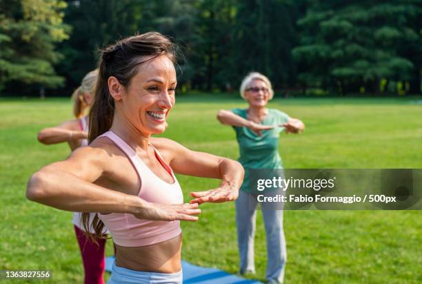 group of middle-aged and senior women training with fitness coach at park - baby boomer stock pictures, royalty-free photos & images