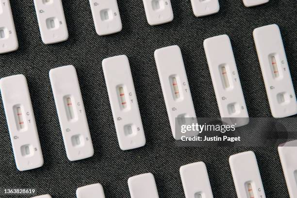 abstract photo of rows of used lateral flow tests - several showing positive results - medical test stock pictures, royalty-free photos & images