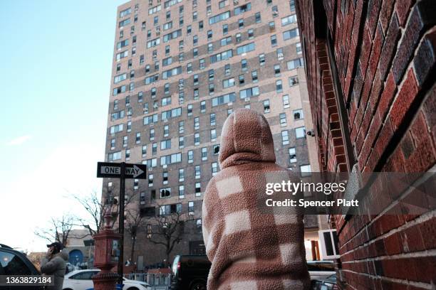 People gather in front of a Bronx apartment building a day after a fire swept through the complex killing at least 19 people and injuring dozens of...