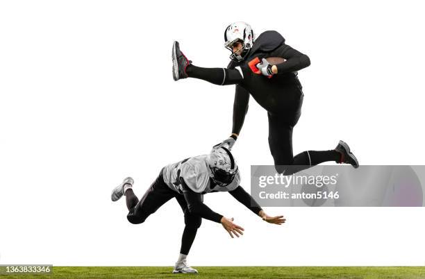 two american football players in action, motion. sportsmen fight for ball isolated on white background on grass - american football player isolated stock pictures, royalty-free photos & images