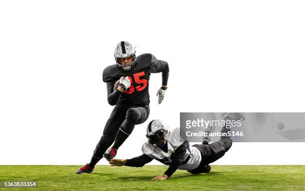 due giocatori di football americano in azione, movimento. gli sportivi combattono per la palla isolati su sfondo bianco sull'erba - quarterback foto e immagini stock