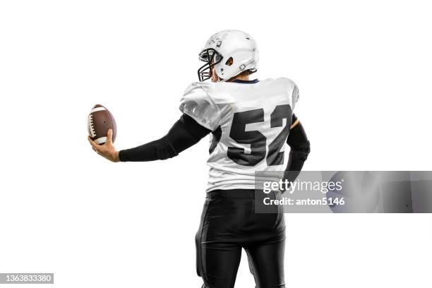 studio shot of strong athlete, american football player wearing sports uniform posing isolated on white background. - american football player white background stock pictures, royalty-free photos & images