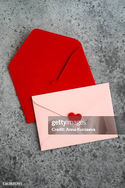 close-up of red and pink envelopes on grey concrete background, top view. valentine's day card. - red card envelope stock pictures, royalty-free photos & images