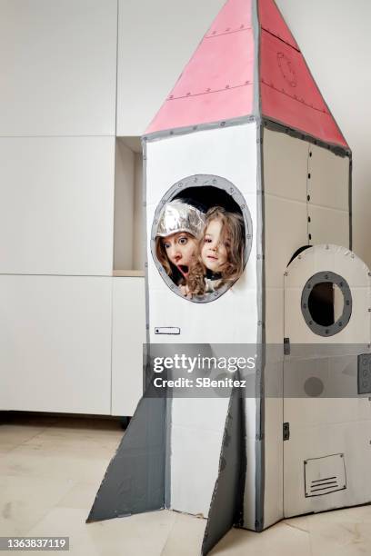 mother and daughter in a space rocket - astronaut helm stock-fotos und bilder